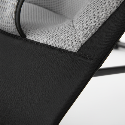 Close-up of a chair with black and gray mesh design on a light background