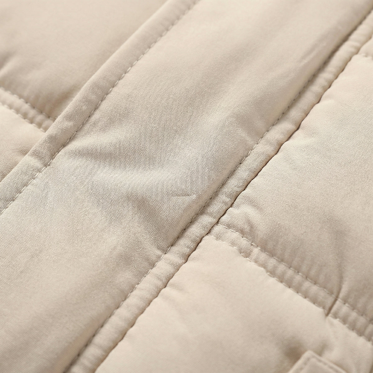 Close-up of a beige quilted fabric surface