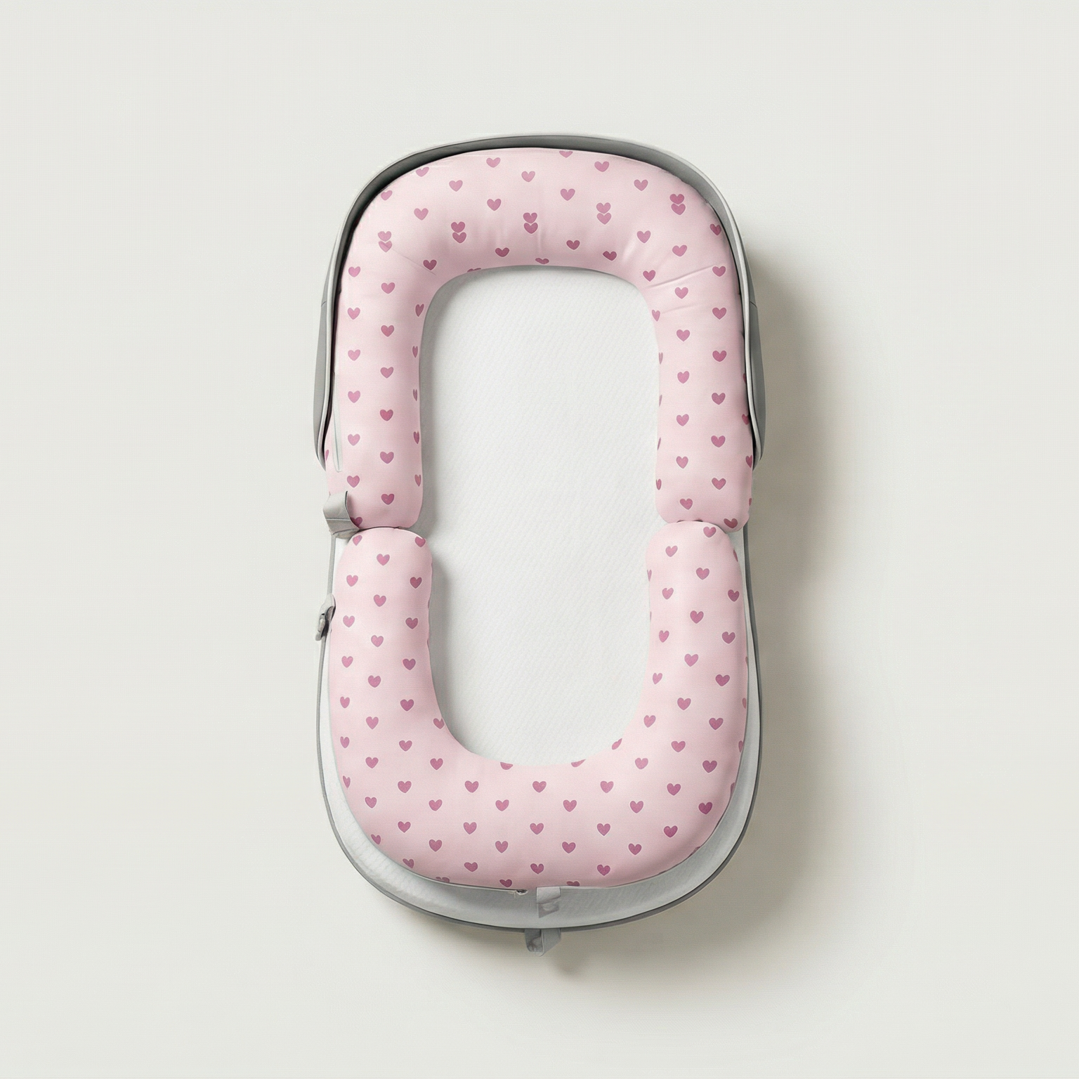 Pink polka dot travel pillow on a light gray background