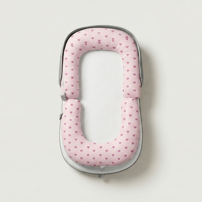 Pink polka dot travel pillow on a light gray background