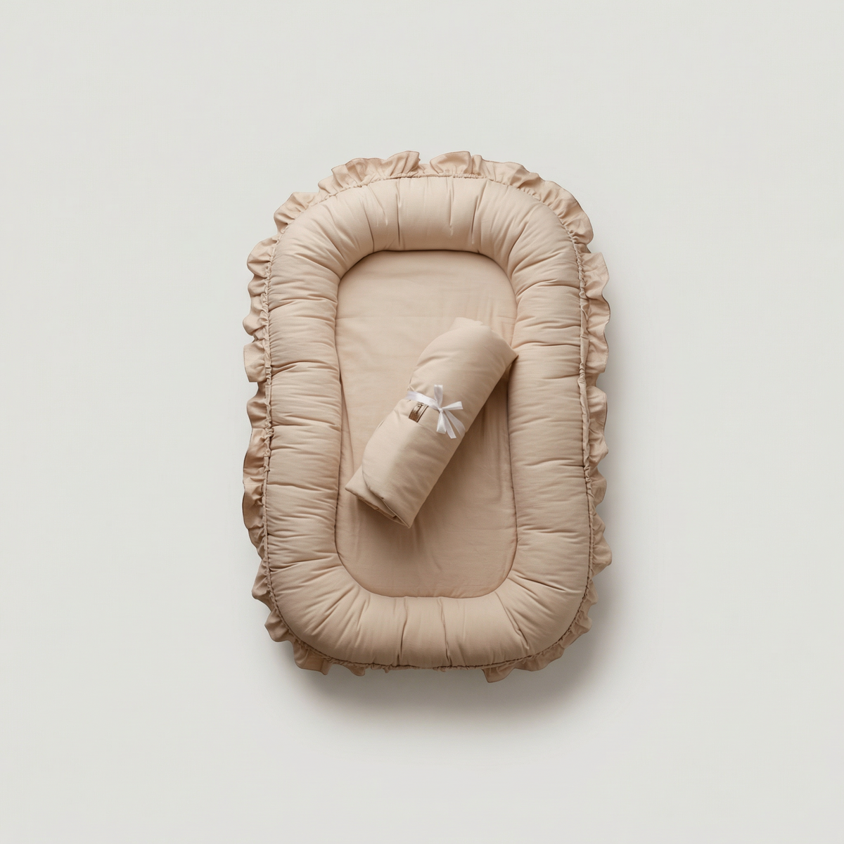 Beige baby nest with ruffled edges on a light gray background