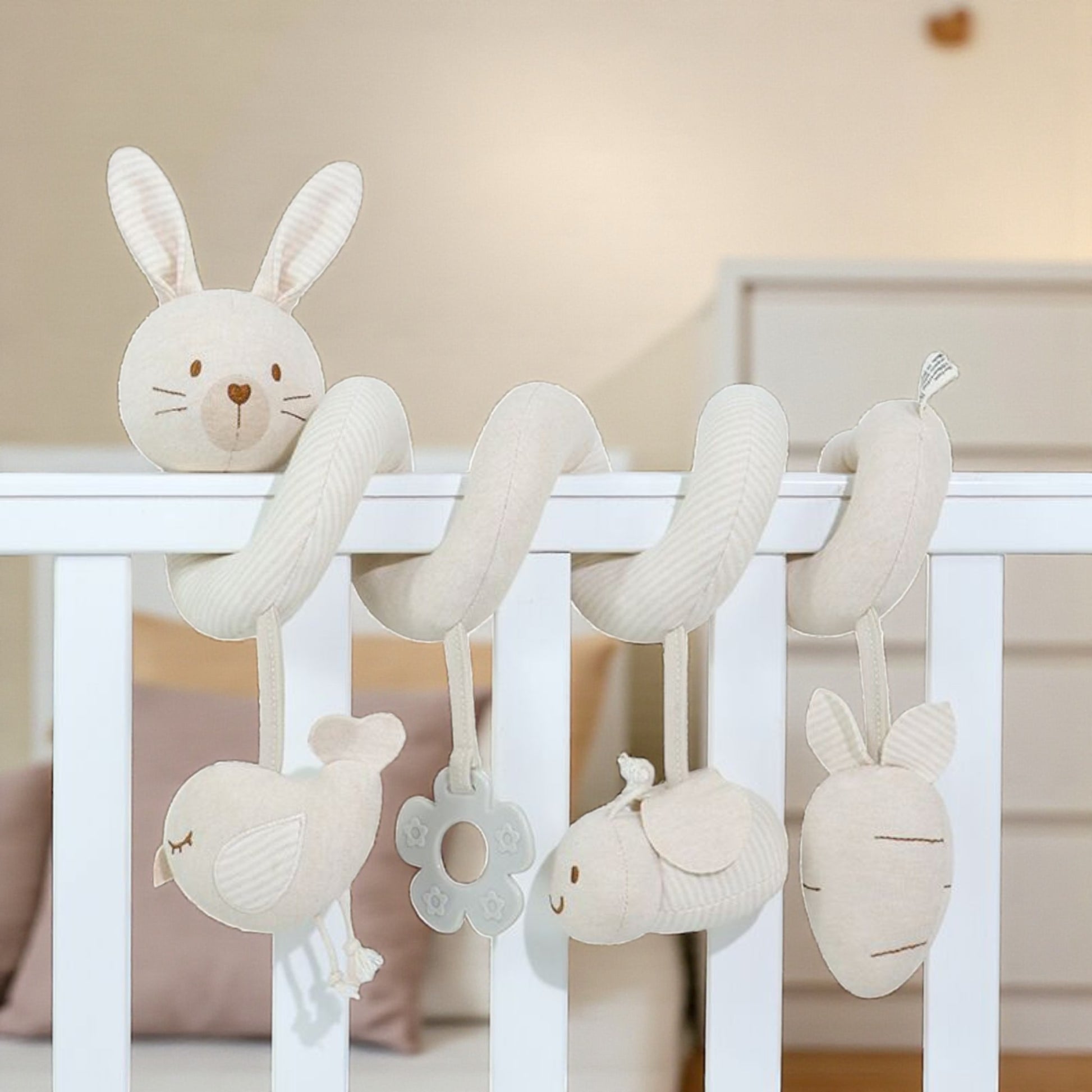 Baby crib mobile with hanging plush toys in a nursery setting
