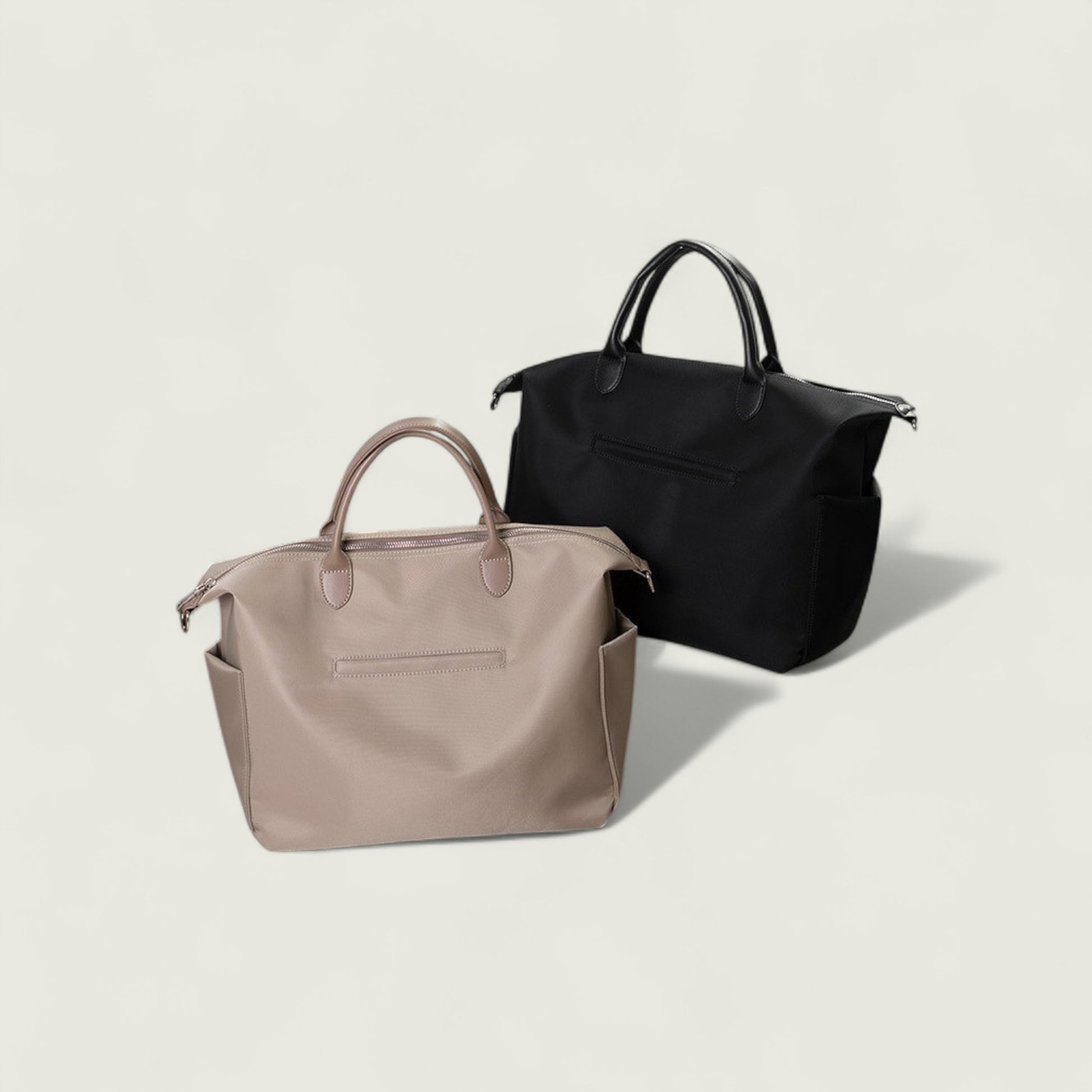 Two handbags, one beige and one black, on a light beige background