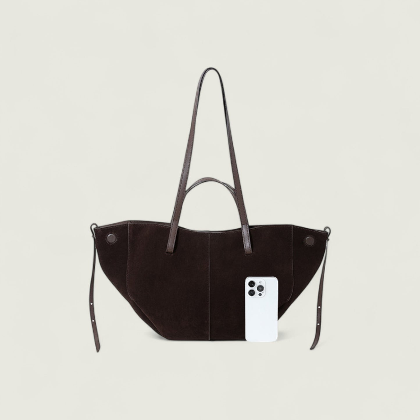 Black handbag with a phone inside on a light gray background