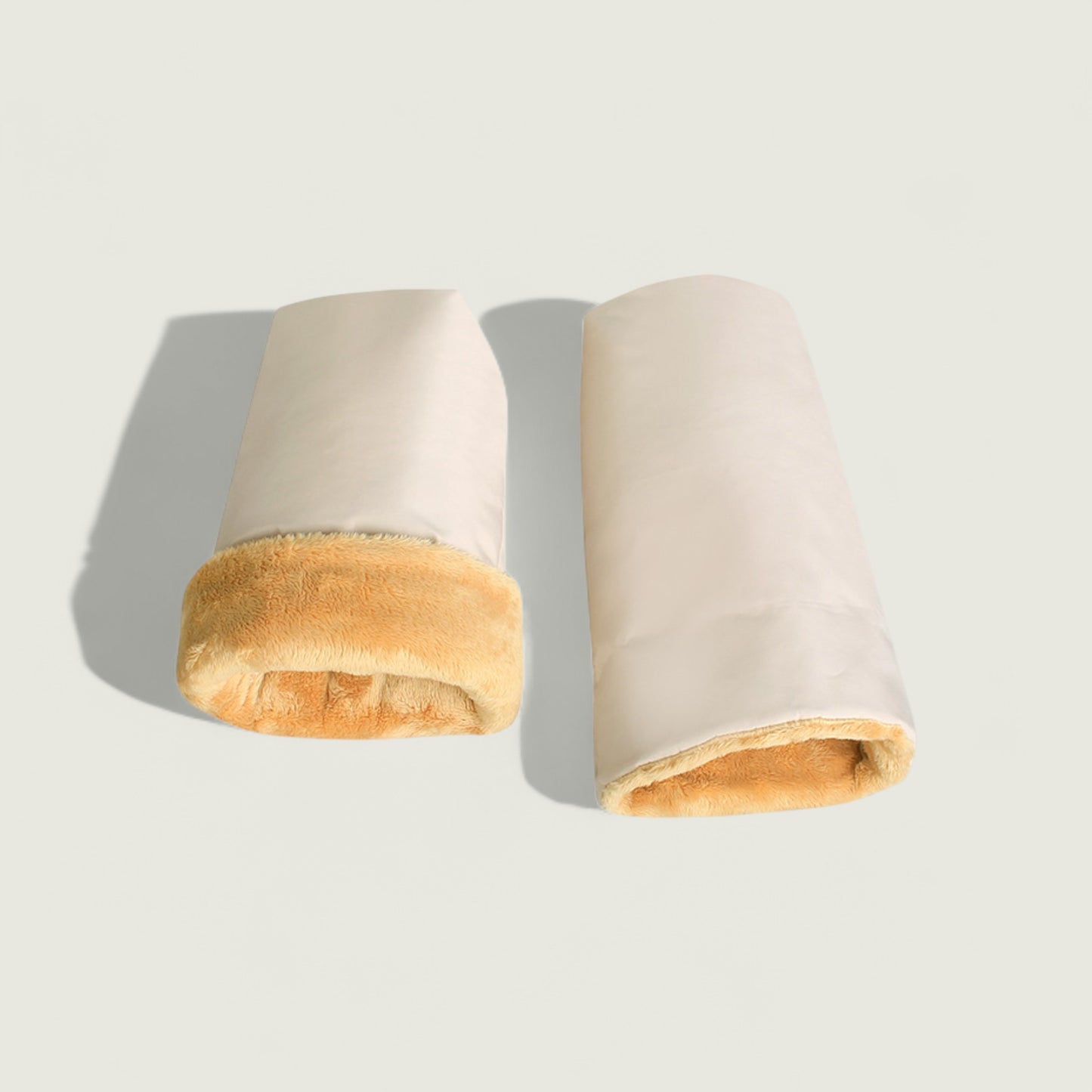 Two cylindrical bread rolls on a light gray background