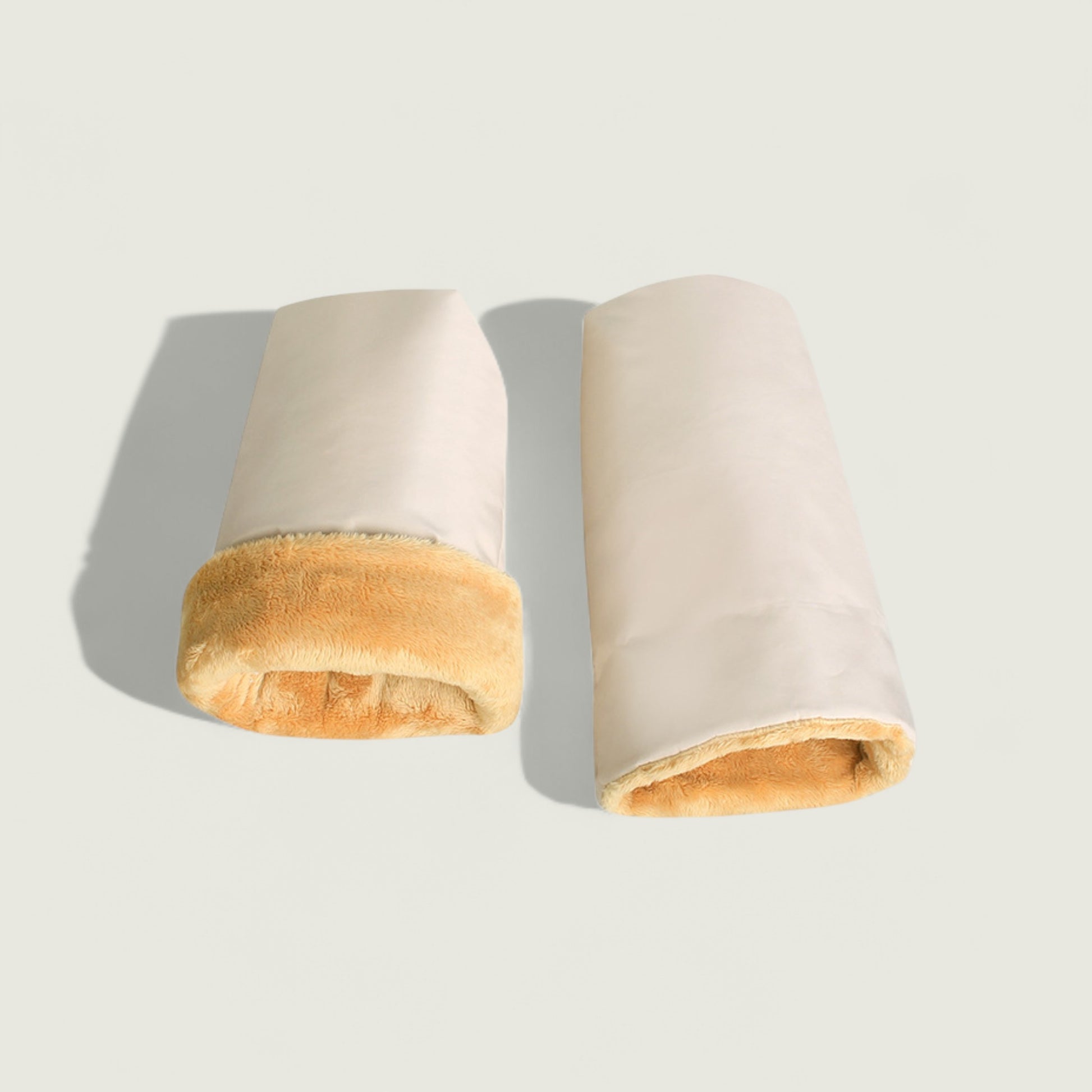 Two cylindrical bread rolls on a light gray background