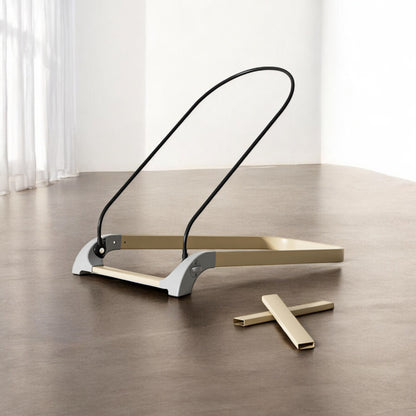 Modern floor lamp with a black curved arm and gold base on a wooden floor.