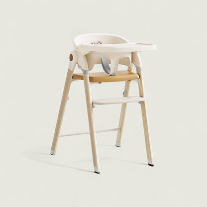 Children's high chair with white seat and wooden legs on a light background