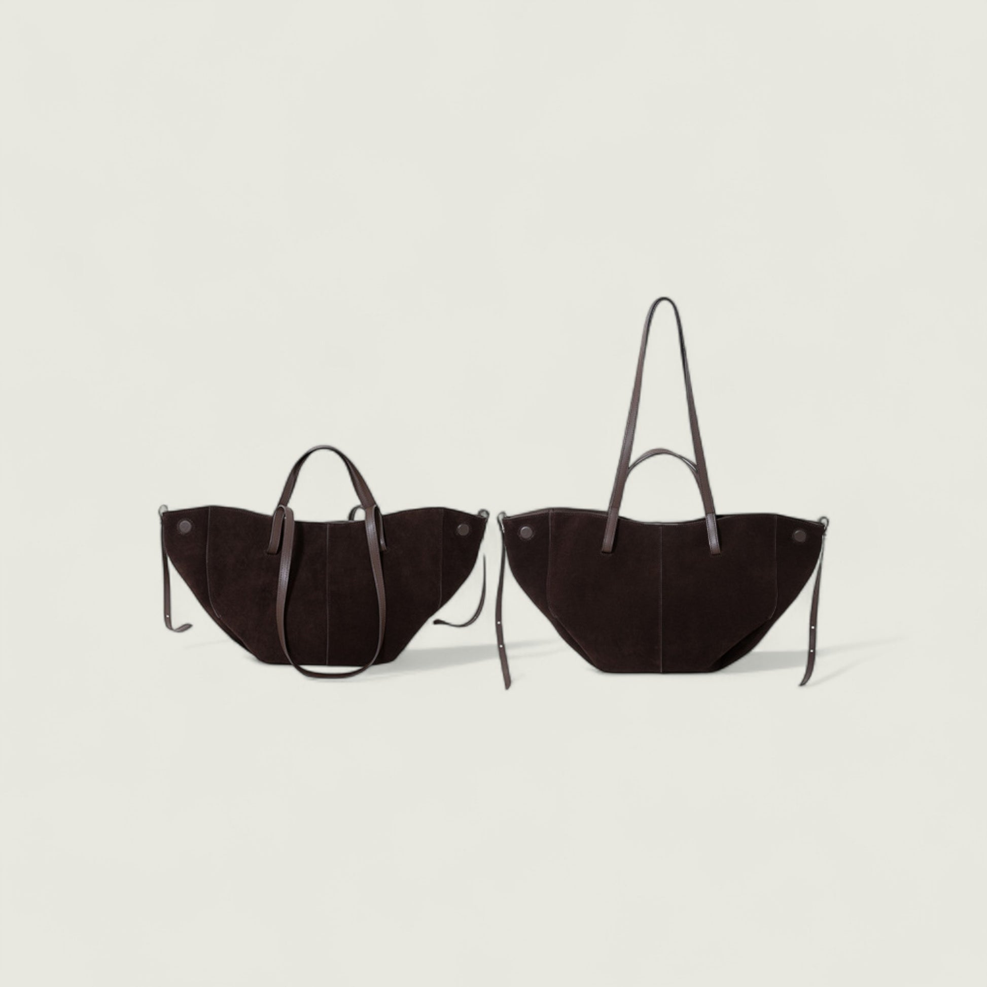 Two brown handbags with handles on a light gray background