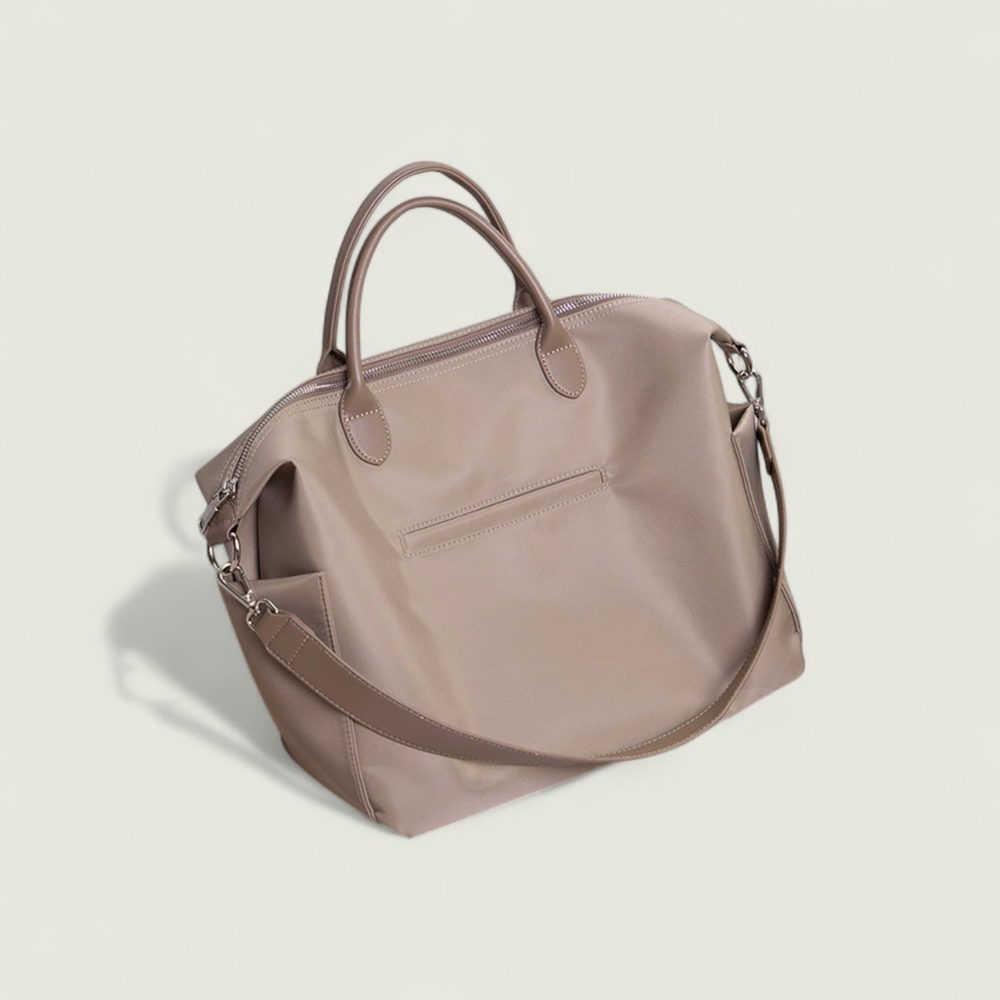 Beige handbag with a shoulder strap on a light beige background
