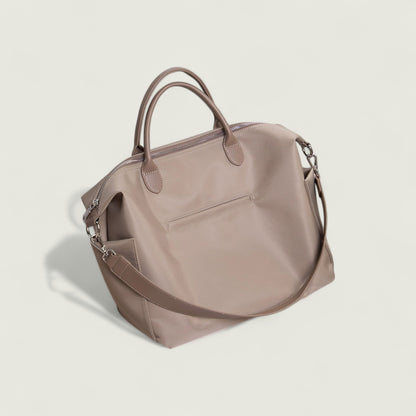 Beige handbag with a shoulder strap on a light beige background