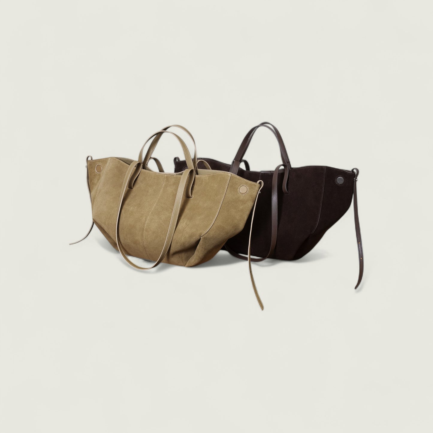 Two handbags, one brown and one black, on a light beige background