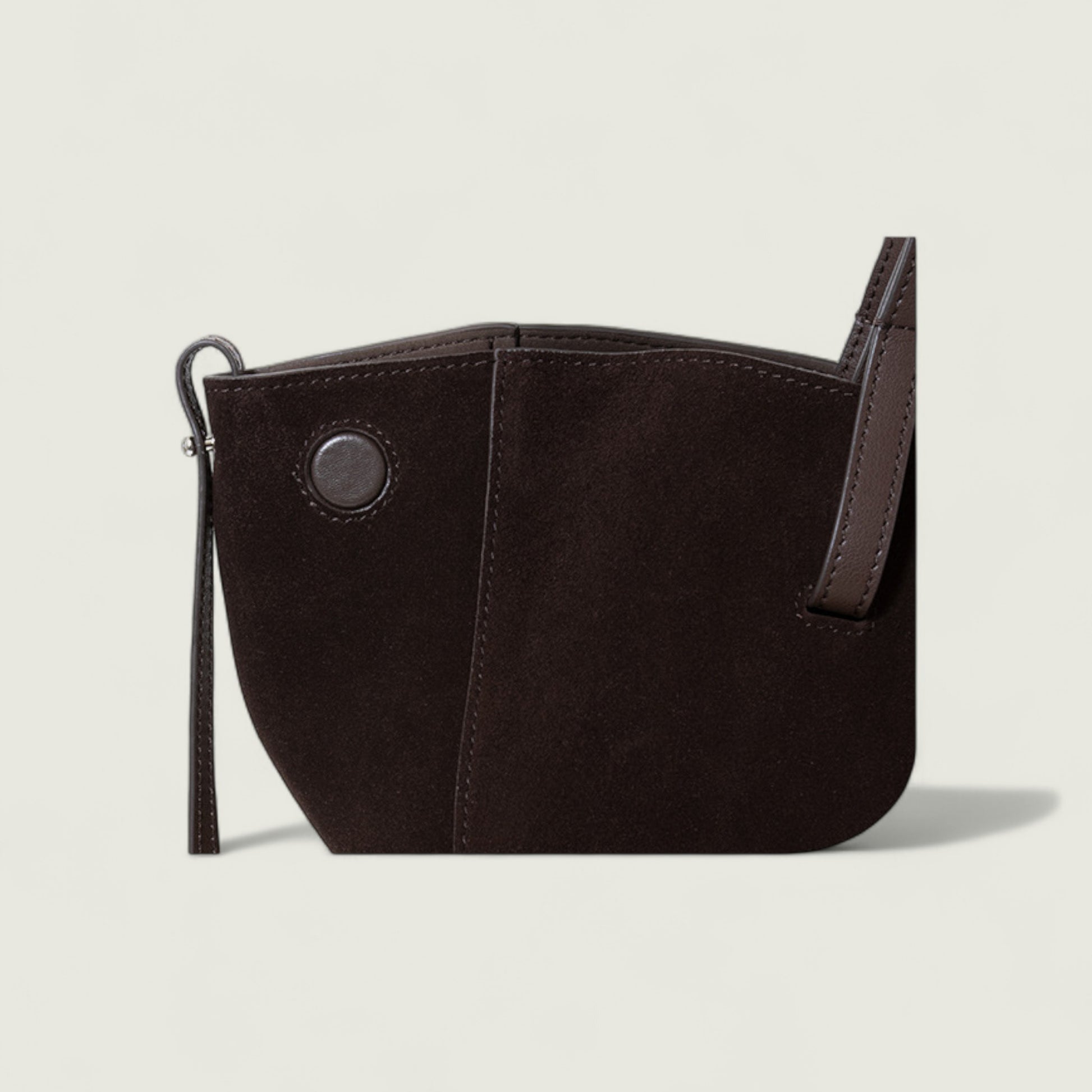 Black leather handbag with a strap on a beige background