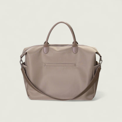 Brown handbag with a shoulder strap on a light beige background