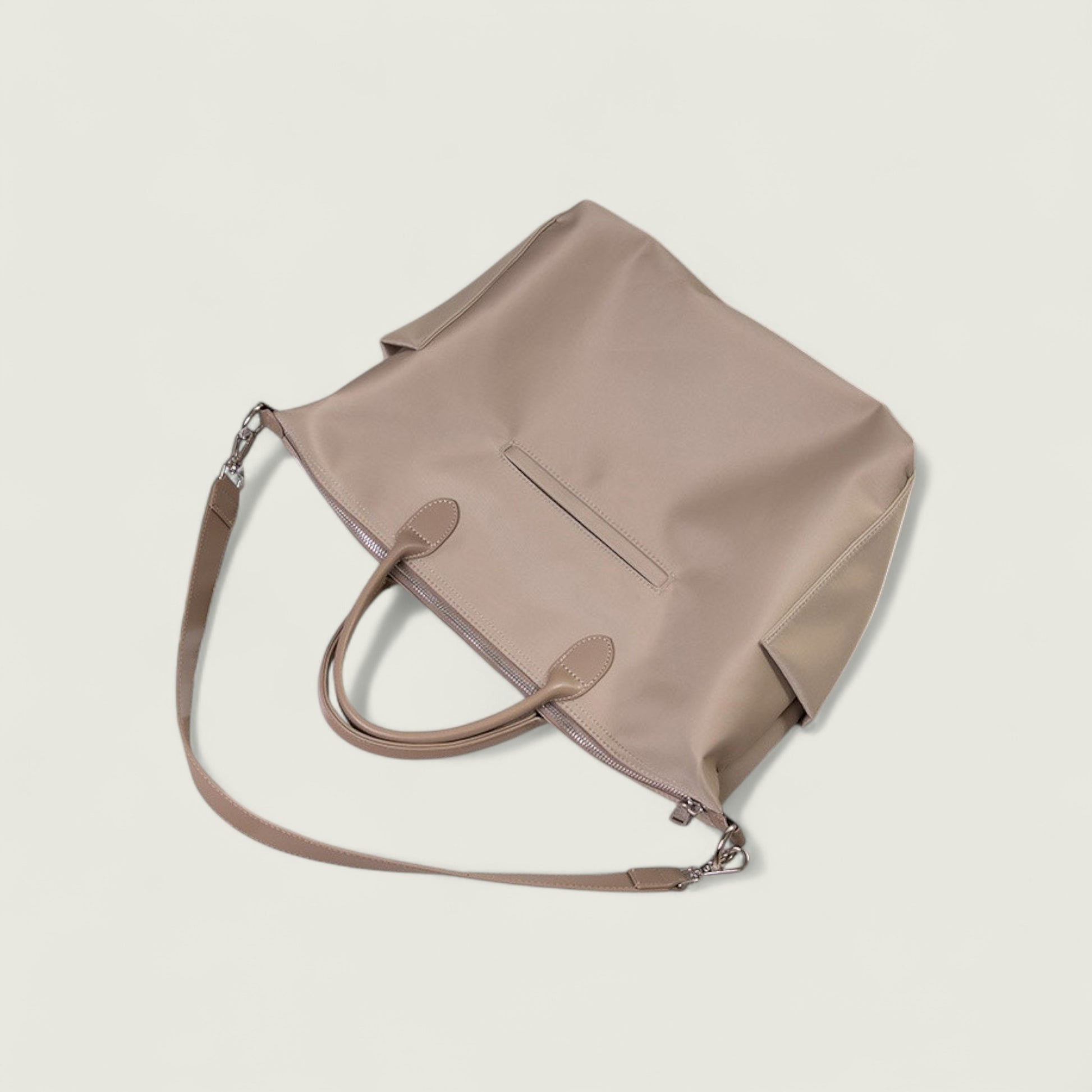 Beige handbag with a shoulder strap on a light beige background