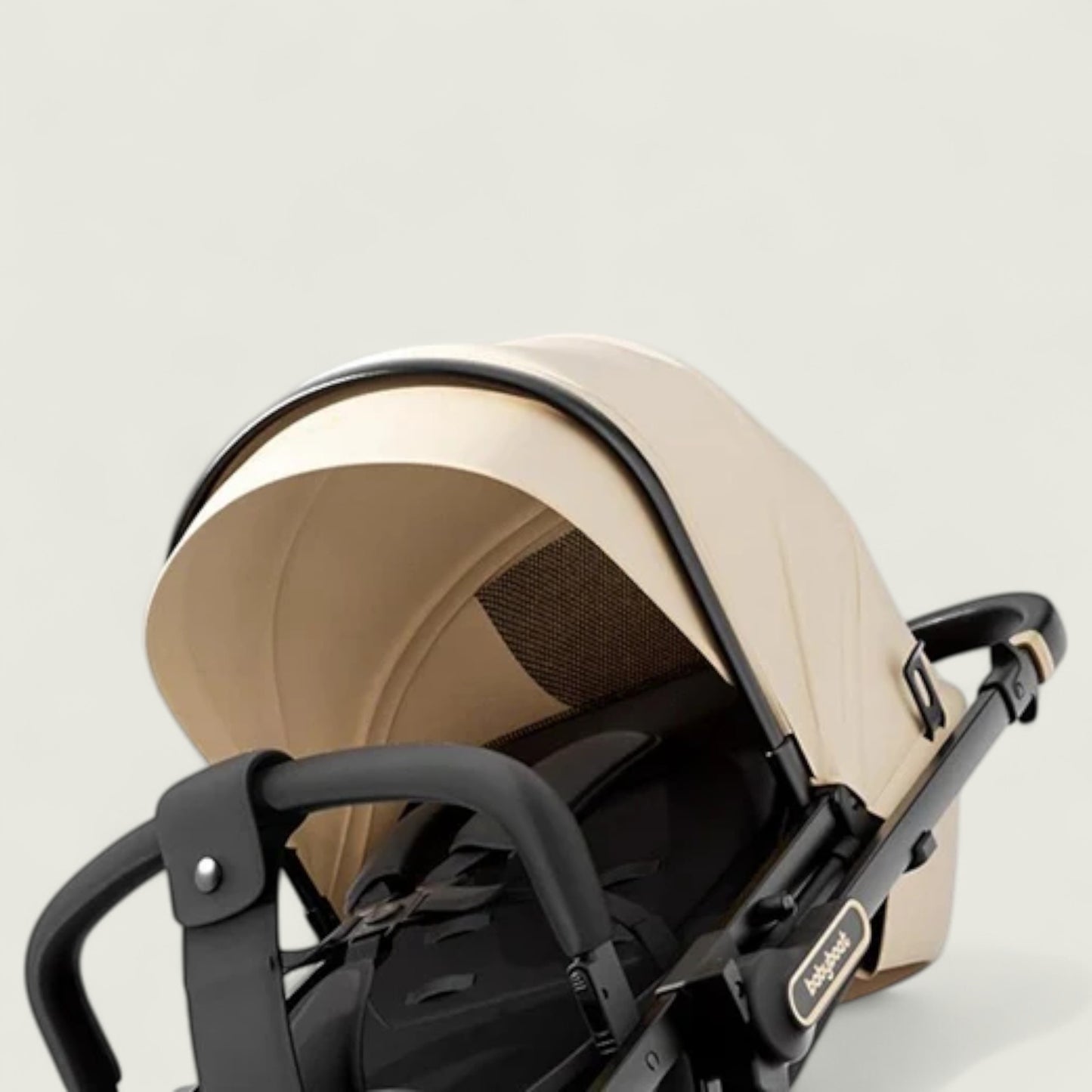 Beige and black stroller on a light gray background