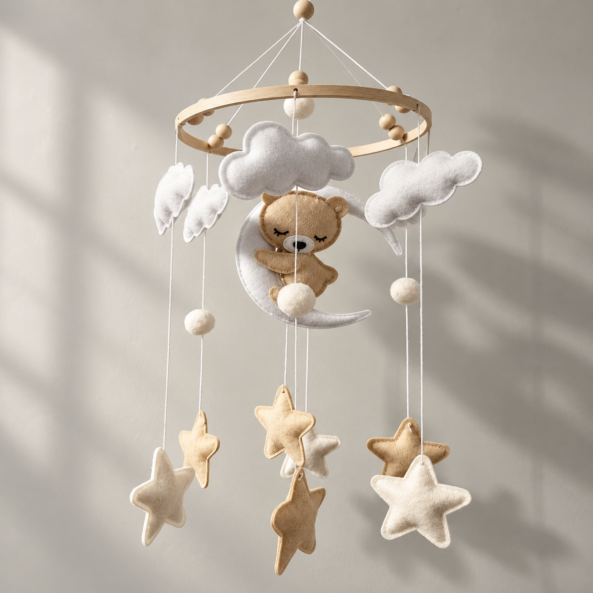 Bear on the Moon felt mobile hanging in soft daylight, with wooden hoop, clouds and stars