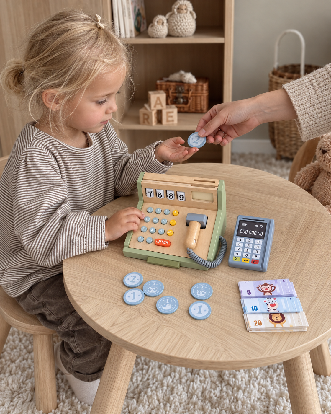 Child playing shop at a wooden table with the cash register, card terminal and play money