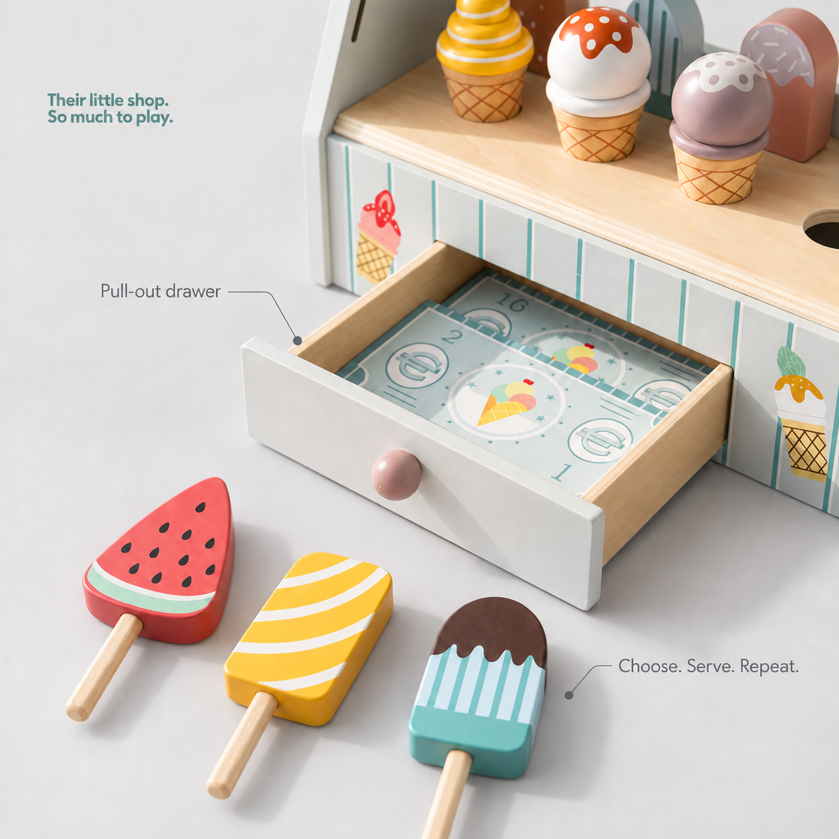 Ice cream play stand detail with pull-out drawer, illustrated play money and three wooden popsicle shapes.