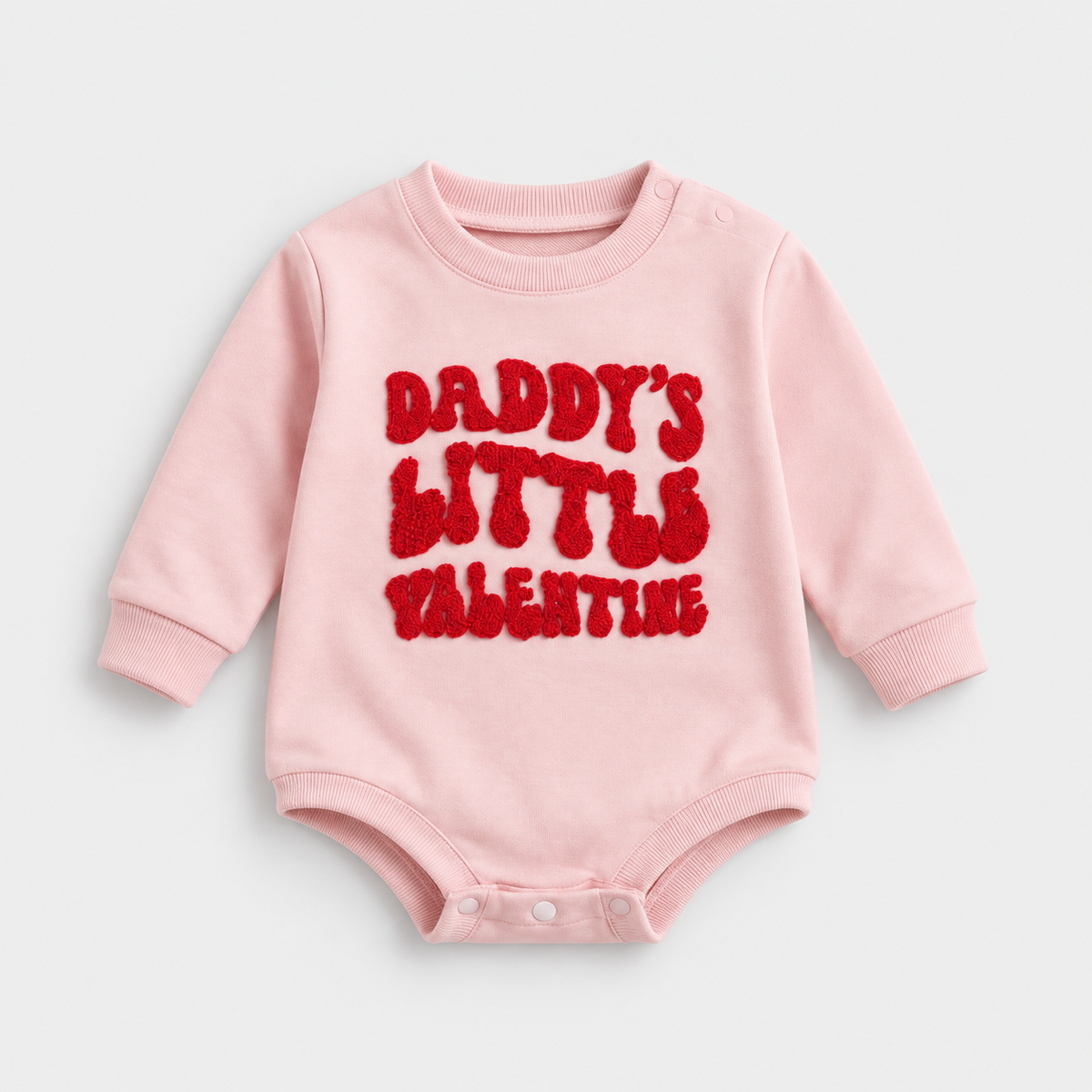 Little Valentine pink long-sleeve romper with red Daddy’s Little Valentine lettering, shown on a light grey studio background.