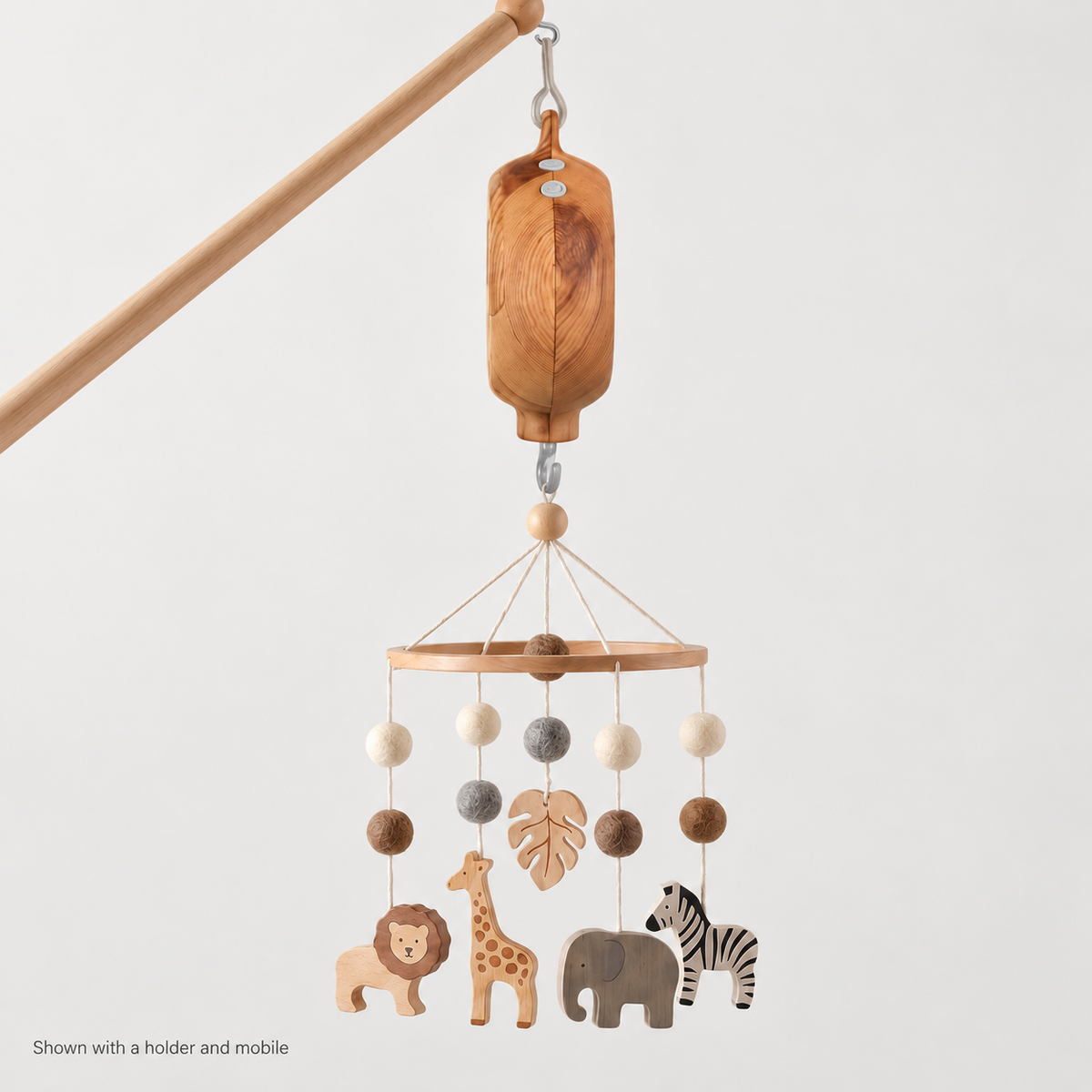 Lullatone music box shown hanging between a wooden holder and safari mobile