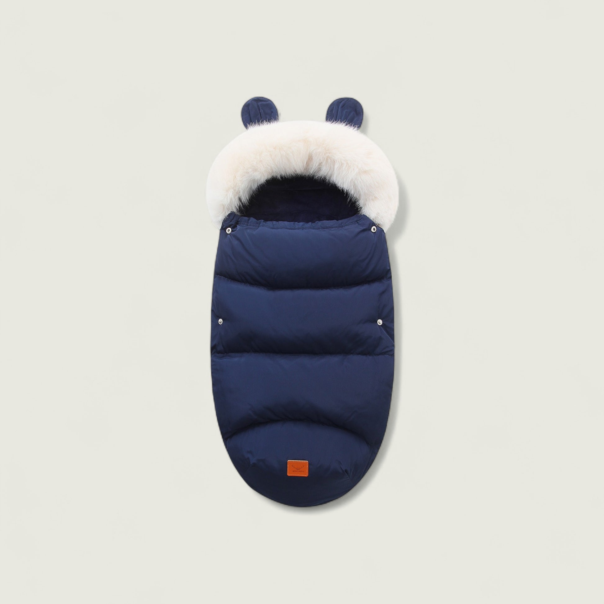 Navy blue baby sleeping bag with white fur hood on a light gray background