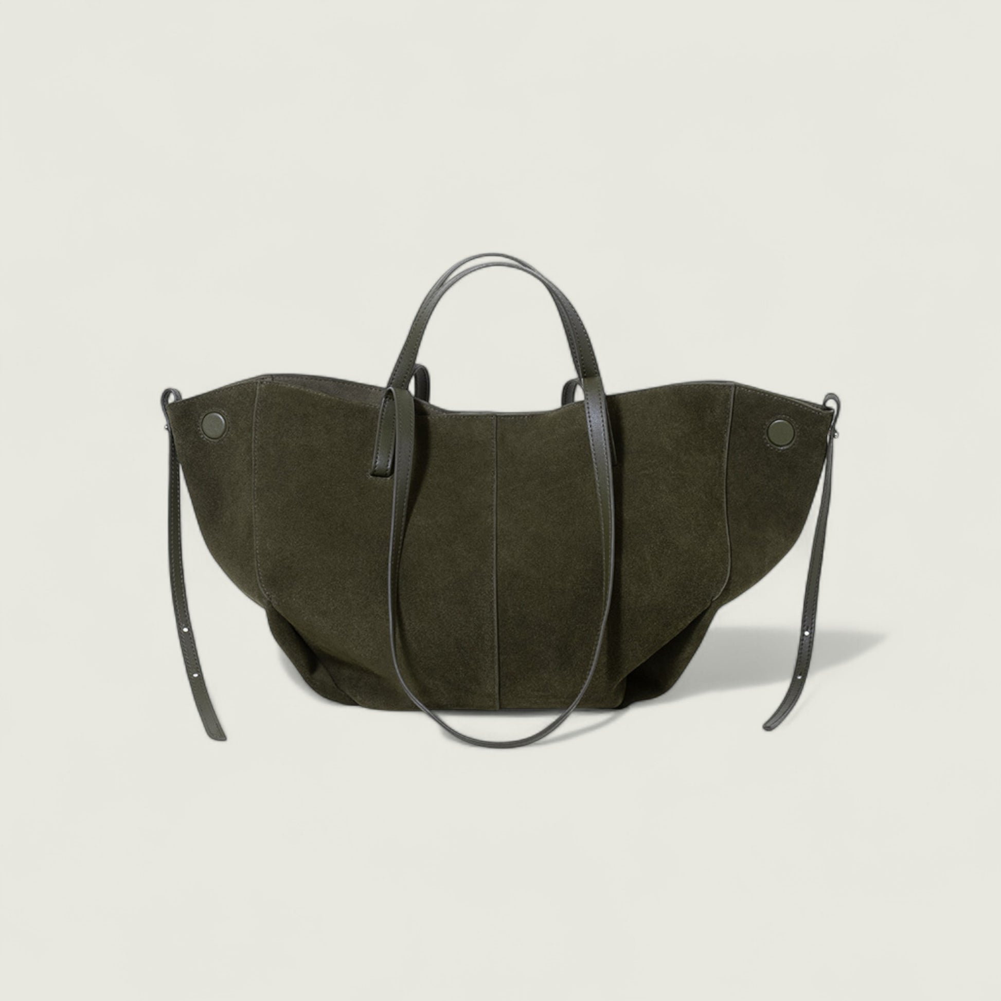 Dark green handbag with black straps on a light beige background