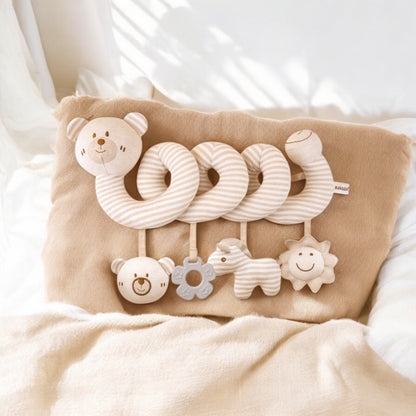 Baby comfort toy with soft textures and animal shapes on a beige pillow.