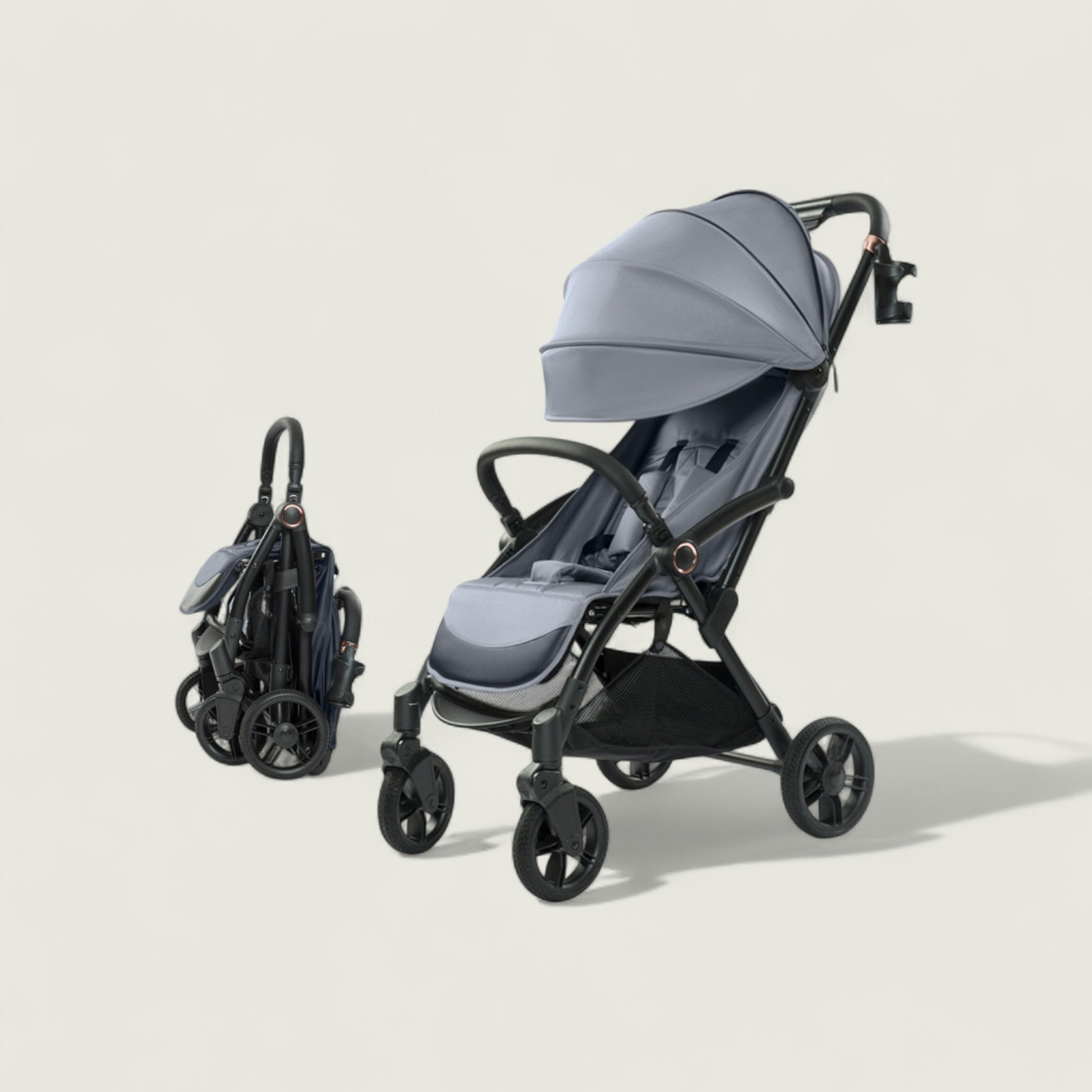 Gray stroller with folded black bag on a beige background
