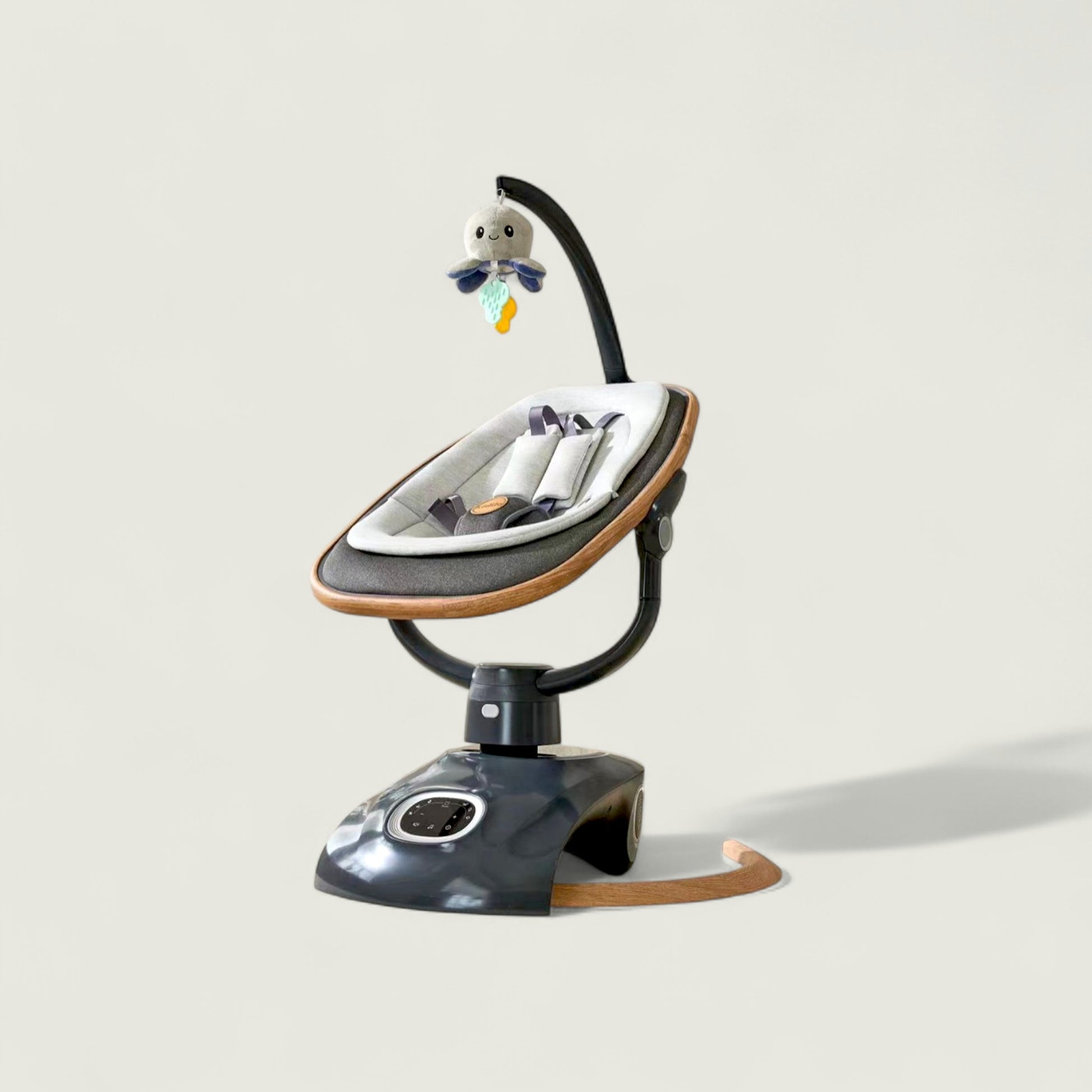 Baby swing with a toy on a light gray background