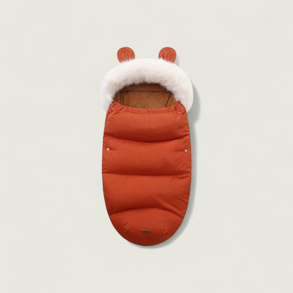 Orange baby footmuff with white fur lining and brown interior on a light gray background